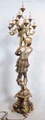 A parcel gilt and silvered floorstanding large figure of a Blackamoor holding a cornucopia shell