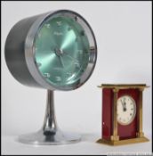 A vintage retro 1970's Rhythm alarm clock on chromium stand together with a Swiza 8 day small