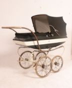 A large and good condition 1970's pram with the original green fabric body with white stripe having