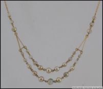 A 1930s part 9ct gold and faux pearl festoon necklace with spring hoop clasp. Measures 16 inches.