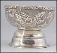 A silver Islamic finger bowl having mythical carp design on raised base,