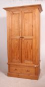 A Victorian style pine single wardrobe having plinth drawers base with double door wardrobe above.