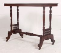A Victorian mahogany side / writing table being raised on turned supports with spindle gallery