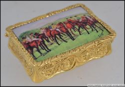 A gold plated over silver pill / snuff box with pictorial Horse racing enamel scene lid.