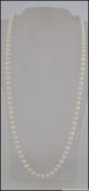 A good long pearl necklace with pearls strung on a knotted string. Measures 30 inches.