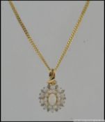 A hallmarked 9ct gold pendant necklace with opals and diamonds in a cluster setting.