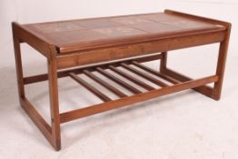 A 1970's Danish influence teak and tile top coffee - occasional table raised on suspension set legs
