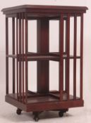 An Edwardian style mahogany inlaid revolving bookcase raised on castors to the base.