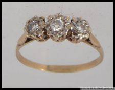 A hallmarked 9ct gold trilogy ring with three diamonds in cathedral setting. Hallmarked London.