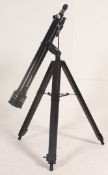 A 20th century Tasco Telescope and lens being raised on a wooden adjustable tripod base.