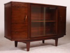 A 1950's walnut bookcase sideboard cabinet having glass centre with cupboards raised on tapered