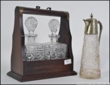 A contemporary tantalus in mahogany case with 2 decanters. Together with a silver plate claret jug.