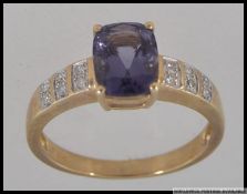 A hallmarked 9ct gold dress ring with large cushion cut Amethyst in a prong setting with diamond
