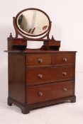 An Edwardian mahogany dressing table - chest of drawers having an oval swing mirror over short and