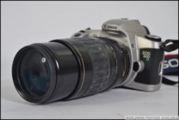 A Canon EOS camera complete with the lens in a carry case