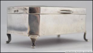 A Walker & Hall silver hallmarked trinket box having shaped legs with casket body and hinged top