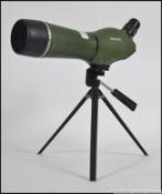 A Summit sporting scope in green body raised on tripod.