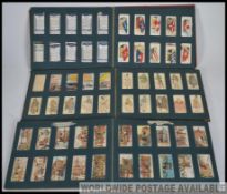 A collection of 3 Wills cigarette card albums being filled in the main.