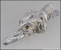 A large silver plated paper clip in the form of a dog with glass eyes