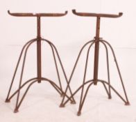 A pair of vintage mid century Industrial adjustable cast metal trestles raised over hairpin style