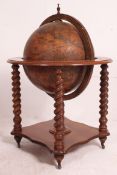 A good quality 20th century drinks globe raised on bobbin supports having hinged centre and