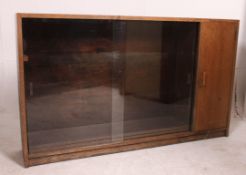 A mid 20th century oak lawyers bookcase cabinet having sliding glass bookcase with cupboard to the