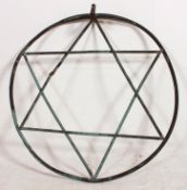 A large 20th century cast metal garden wall sculpture in the form of a star within circle.