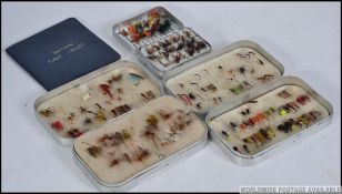 A collection of vintage fishing flies in the alloy tin cases together with a cast wallet of flies