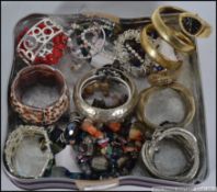 A collection of costume jewellery bangles of varying designs to include watch bangles etc please