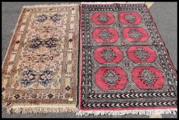 2 Turkish 20th century machine woven rugs, one with red ground and black geometric design,