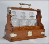 An early 20th century Creakes Patent silver plate and oak 3 piece decanter tantalus.