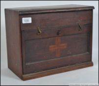 An early 20th century wooden first aid box being marked with the cross ( faded) having drawers and