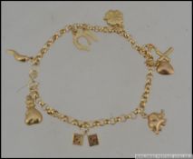 An Italian 9ct gold charm bracelet with horn of plenty dice horse shoe clover money bag heart