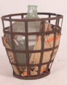 A vintage early 20th century glass acid carboy bottle complete in the original strap iron casket /