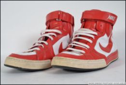 A pair of Nike Air Flytop basketball books in red and white leather with lace and velcro straps.
