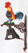 A cast iron 20th century hand painted wall decor exterior bell, with cockerel decoration to top.