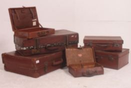 A stack of vintage suitcases to include varying sizes and styles all dating from the early 20th