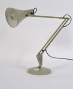 A vintage post war Herbert Terry anglepoise lamp in green having a circular terraced base and