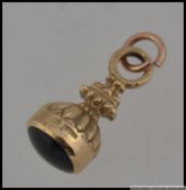 A hallmarked 9ct gold watch fob with scalloped decoration and round bale. Weight 3.9. Measures 2.