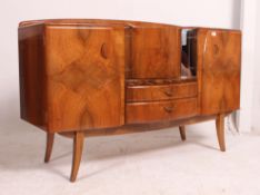 A 1950's walnut drinks cabinet / sideboard having revolving centre over drawers with cupboard