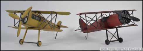 2 20th century tin plate models of vintage aeroplanes - bi-planes in red and yellow.