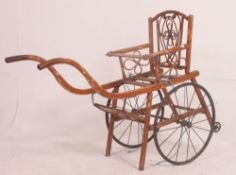 A 19th century blond wood continental pouchette with spoked wheels having bentwood push handles