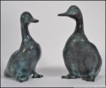 A pair of 20th century bronze ducks being hollow cast, each with carved detailing feathers etc.
