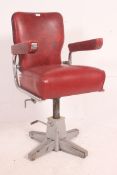 A 1950's red vinyl and polished chrome barbers chair raised on quadruped base having overstuffed