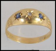 An antique 18ct gold ring set with sapphires and diamond in a domed star cut setting. Weight 2.9g.