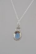 A 925 silver pendant necklace with central blue topaz with CZ halo strung on a fine 925 silver