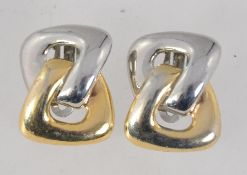 A pair of vintage yellow and white metal clip on earrings in a oblong knot. Measures 3cms.