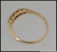 An Edwardian 18ct gold hallmarked diamond ring set with 5 old cut diamonds in a gypsy setting