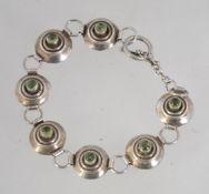 A tested 925 silver bracelet set with peridot cabochons with toggle clasp fastening. Measures 19cms.