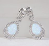 A pair of silver and cz adorned teardrop earrings, the central opalite peardrops with cz borders.